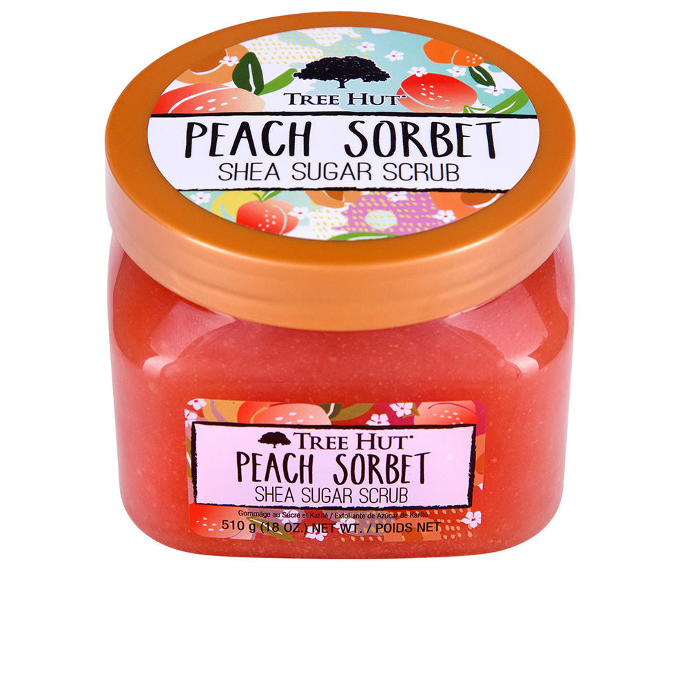 Tree Hut Bright orange peach-scented body scrub in plastic jar with metallic lid, colorful fruit-label, translucent scrub visible