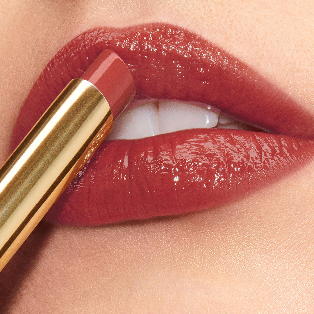Estée Lauder Rose-gold capped lip gloss wand applying glossy vibrant pink color, expert-crafted finish