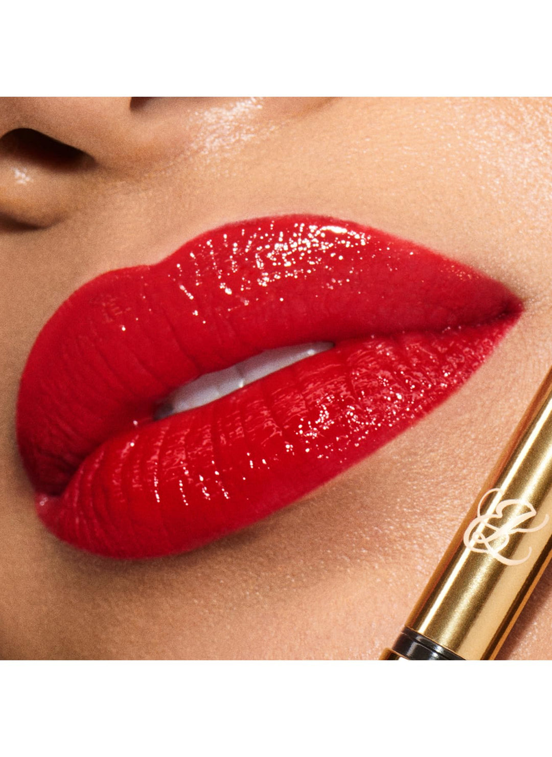 Glossy red cream lipstick in fluted rose‑gold case, precise bullet tip