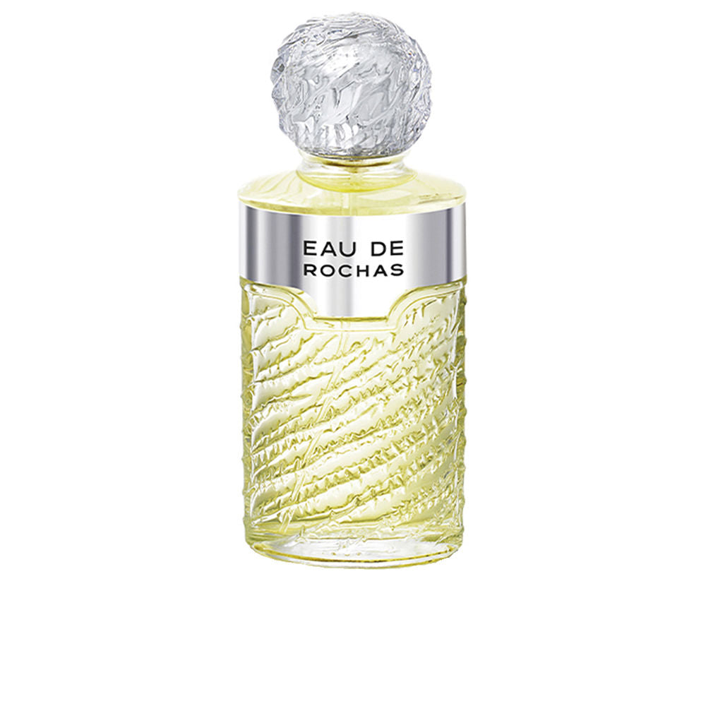 Clear glass bottle of Eau de Rochas with rippled design, citrus and floral scent.