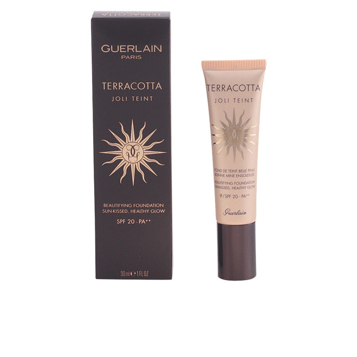 Black and beige tube with gold sun emblem, plastic tube and cardboard box, Guerlain