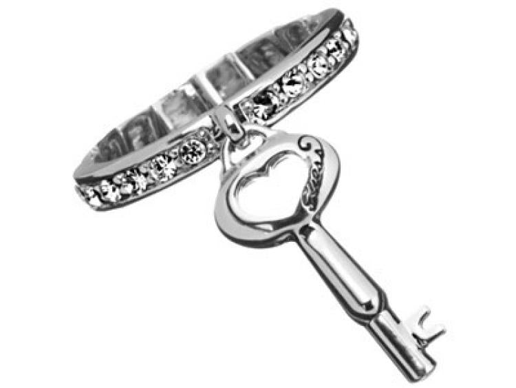 Silver ring with embedded crystals and dangling key charm with heart cutout beside a black presentation box